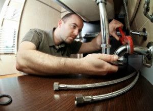 Plumber working under a sink