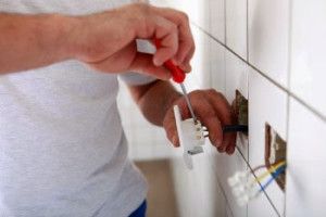 Electrician installing a wall outlet