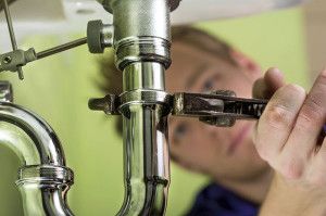 Plumber repairing under sink